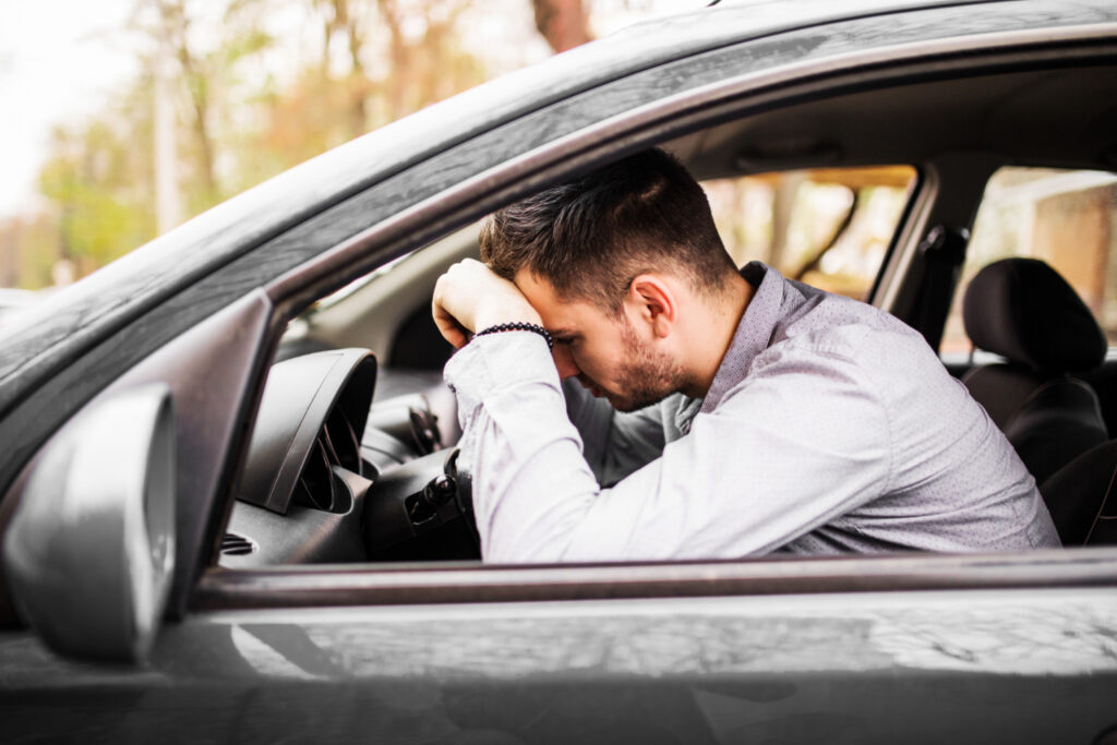 jovem-sentado-no-carro-muito-chateado-e-estressado-apos-falha-grave-e-movendo-se-no-engarrafamento