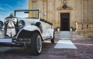 White classic car for a traditional wedding in front of a church