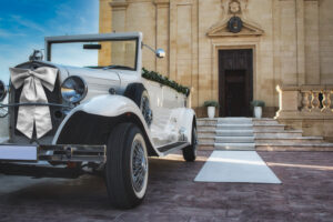 White classic car for a traditional wedding in front of a church