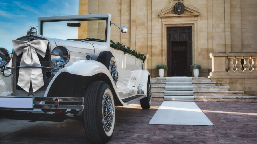 White classic car for a traditional wedding in front of a church